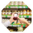 Couple choosing jar of marmalade, reading nutrition label
