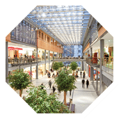Image taken inside a shopping mall. There are lots of people walking around going to stores, buying things and consuming food and beverages. There are two floors with shops and boutiques. The ceiling is glass. The architecture is very modern and new and the general feel of the images is bright, clean, safe and positive.