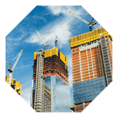 Skyscrapers construction site for modern buildings in New York. Cranes and scaffolding used to build tall structures, blue sky on background.