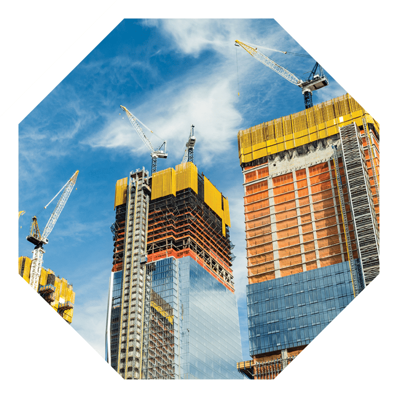 Skyscrapers construction site for modern buildings in New York. Cranes and scaffolding used to build tall structures, blue sky on background.
