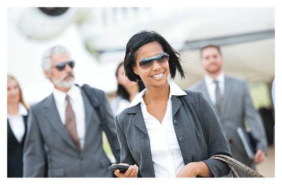 Diverse team of wealthy business executives deboarding private jet